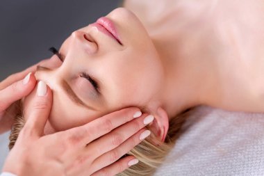 Masaj masasında uzanmış gözleri kapalı rahatlayan genç bir kadın. - Kadın. Spa salonu