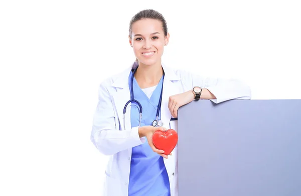 Pozitif kadın doktor stetoskop ve kırmızı kalp sembolü ile ayakta — Stok fotoğraf