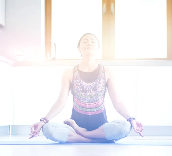 Mujer joven haciendo yoga en casa en la posición de loto. Yoga. Una mujer. Estilo de vida — Foto de Stock