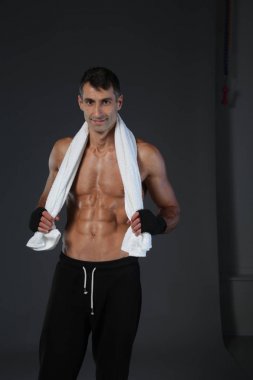 Siyah arka plan üzerine ayakta güçlü atletik adam.