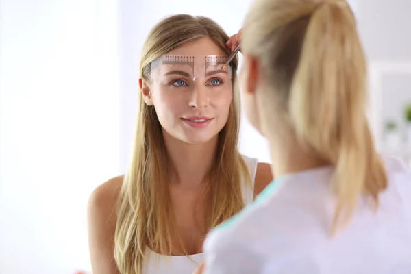 Permanente make-up voor wenkbrauwen. Close-up van mooie vrouw met dikke wenkbrauwen in schoonheidssalon. — Stockfoto