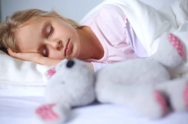 Dítě holčička spí v posteli s hračka medvídek. — Stock fotografie