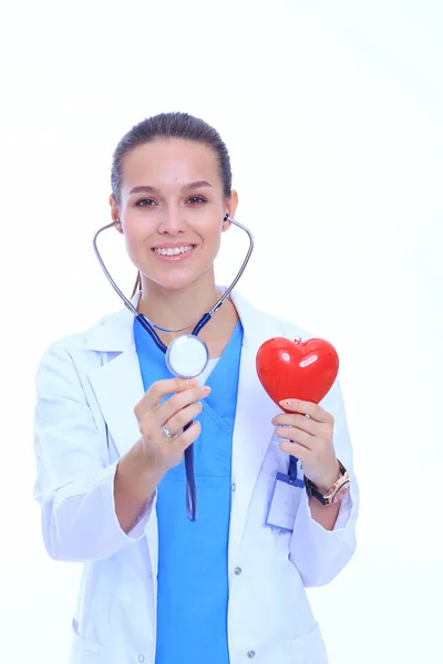 Positieve vrouwelijke arts met de stethoscoop en rood hartsymbool staan geïsoleerd. Vrouw arts — Stockfoto