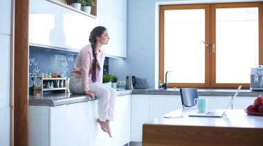 Mutfakta masada oturan genç kadın.