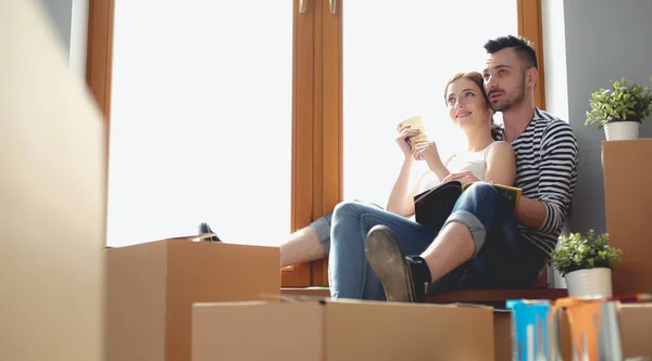 Par som flyttar i huset sitter på fönsterbrädan. Par — Stockfoto