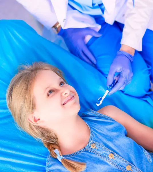 Niña sentada en el consultorio de dentistas — Foto de Stock