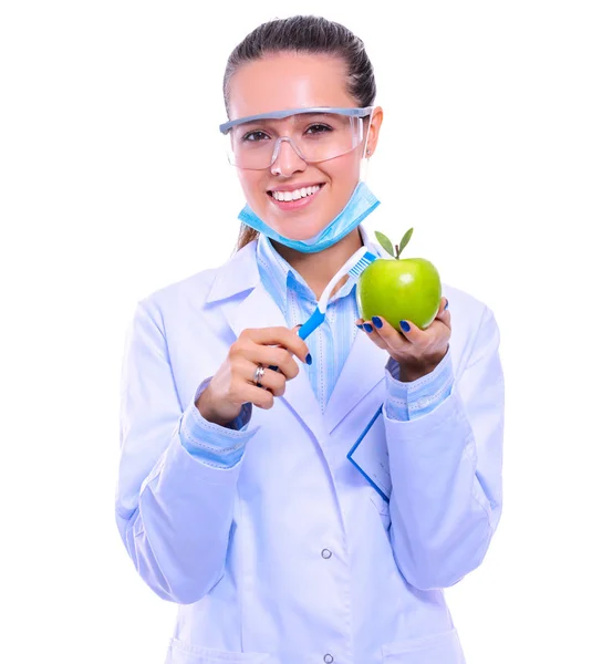 歯医者の女性は手と歯ブラシで緑の新鮮なリンゴを保持しています。歯医者だ。女性医師 — ストック写真
