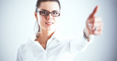 Genç bir kadın ayakta, gri arka plan üzerinde izole