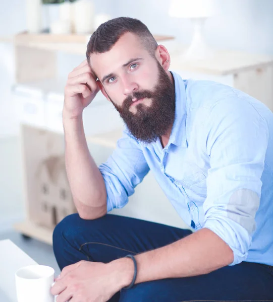 Jonge zakenman zit op stoel in functie — Stockfoto