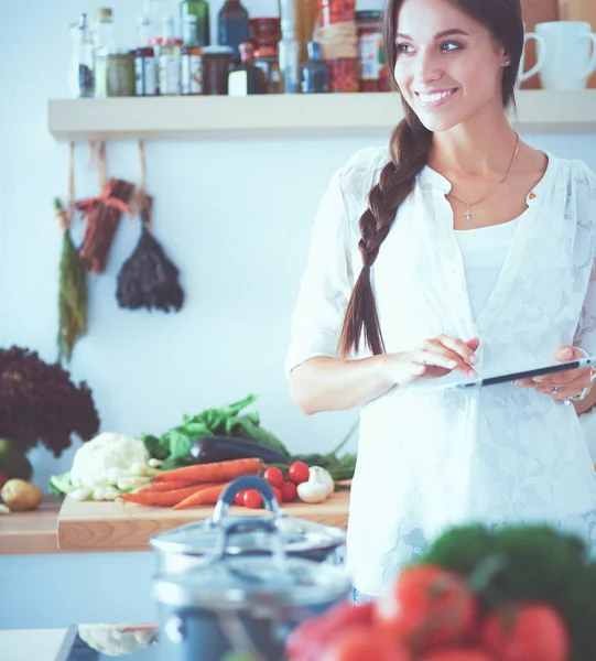 Young woman using digital tablet in the kitchen. Woman drinking coffee and using digital tablet in the morning. — Stock Photo, Image