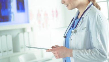 Hastane lobisinde tablet bilgisayar kullanan kadın doktor.