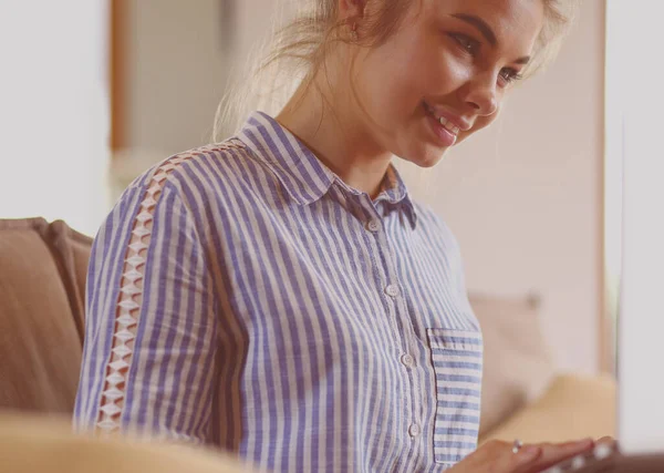 Mujer morena feliz sentado en el sofá con ordenador portátil — Foto de Stock