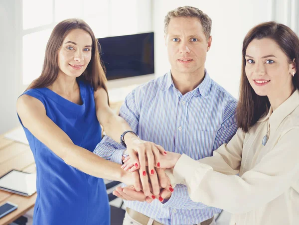 Compañeros de negocios apilando manos juntos en la oficina — Foto de Stock
