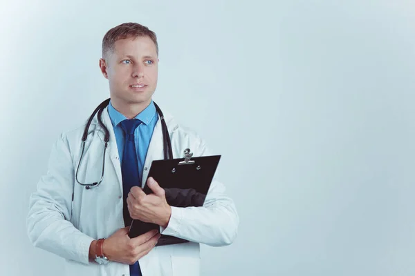 Médico varón de pie con carpeta, aislado sobre fondo blanco — Foto de Stock