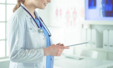 Hastane lobisinde tablet bilgisayar kullanan kadın doktor.