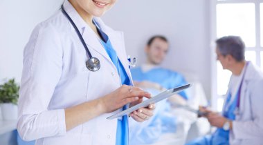 Hastane lobisinde tablet bilgisayar kullanan kadın doktor.