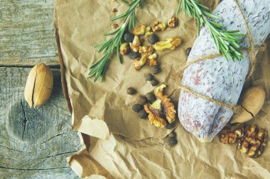 İtalyan salamı, deniz tuzu, biberiye, sarımsak ve fındık. Kırsal tarzda. Üst görünüm.