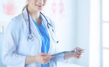 Kadın doktor hastanede dosyayla bekliyor.