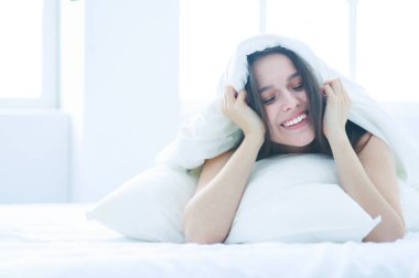 Güzel bir kadın yatağında uzanıyor..