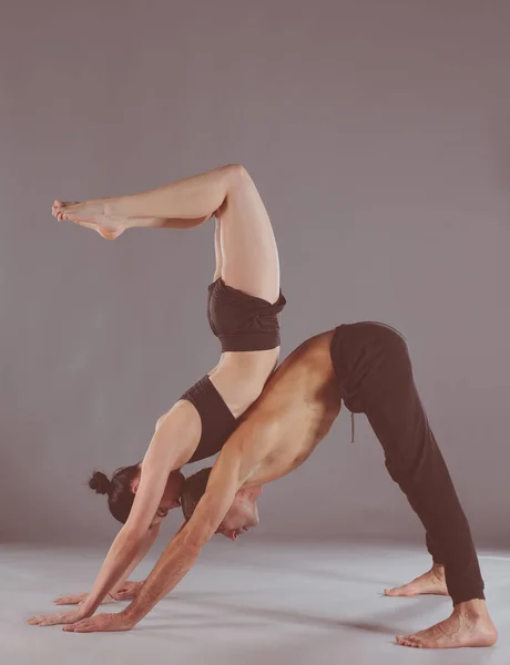 Ungt par öva acro yoga på matta i studio tillsammans. Acroyoga. Par yoga. Partner yoga. — Stockfoto