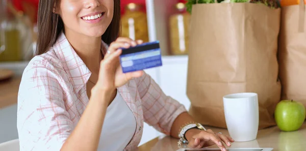 Young woman in the kitchen, using her ipad. Young woman — Stock Photo, Image