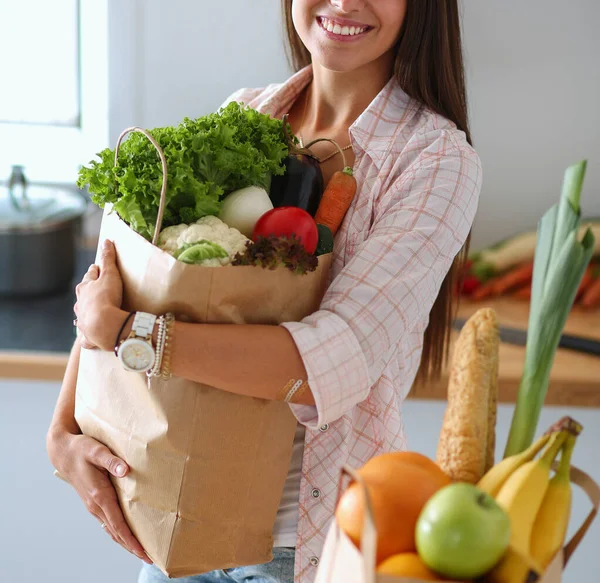 野菜の入った食料品の買い物袋を持っている若い女性。若い女性 — ストック写真