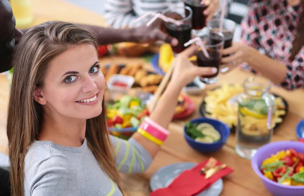 Vista superior do grupo de pessoas que jantam juntas enquanto estão sentadas à mesa de madeira. Comida na mesa. As pessoas comem fast food. — Fotografia de Stock