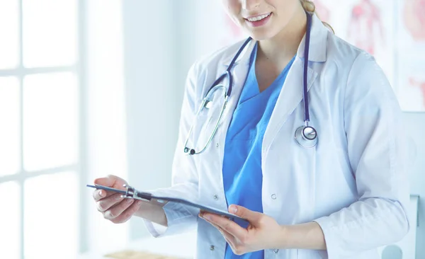 Leende kvinnlig läkare med en mapp i enhetlig ställning — Stockfoto