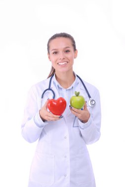 Güzel gülümseyen kadın doktor kırmızı kalp ve yeşil elma tutuyor. Kadın doktor