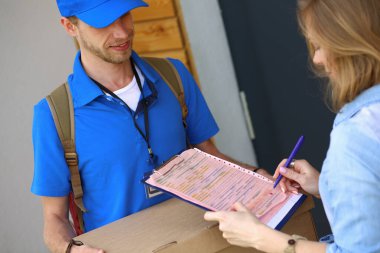Mavi üniformalı gülümseyen kurye servis konseptine paket kutusu teslim eden teslimatçı. Mavi üniformalı gülümseyen teslimatçı.