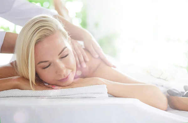 Schöne junge Frau entspannt sich bei einer Ganzkörpermassage im Wellnessbereich — Stockfoto