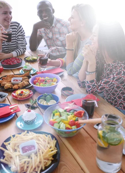 Draufsicht auf eine Gruppe von Menschen beim gemeinsamen Abendessen, während sie am Holztisch sitzen. Essen auf dem Tisch. Menschen essen Fast Food. — Stockfoto