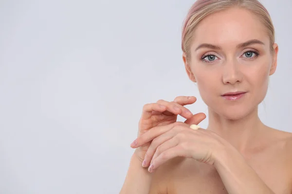 A menina bonita com uma pele fresca limpa toca com uma mão uma bochecha — Fotografia de Stock