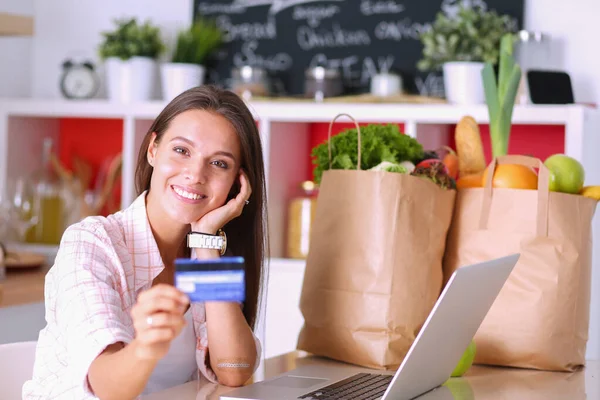 Uśmiechnięta kobieta zakupy online za pomocą tabletu i karty kredytowej w kuchni. Uśmiechnięta kobieta — Zdjęcie stockowe