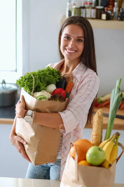 Молода жінка тримає продуктовий сумку з овочами. Молода жінка — стокове фото