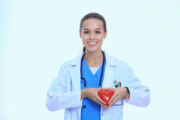 赤いハートと緑のリンゴを持つ美しい笑顔の女性医師。女医 — ストック写真