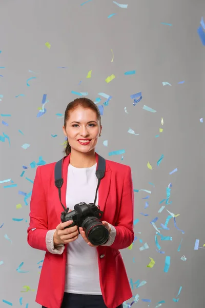 Schöne, glückliche Frau mit Kamera bei einer Feier mit Konfetti. Geburtstag oder Silvester feiern Konzept — Stockfoto