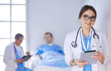 Hastane lobisinde tablet bilgisayar kullanan kadın doktor.