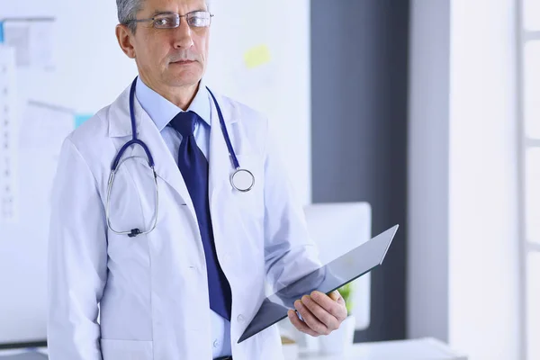 Male doctor writes notes on the clipboard in the hospital — Stock Photo, Image