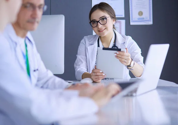 Equipe médica séria usando um laptop em um escritório brilhante — Fotografia de Stock