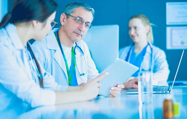 Équipe médicale sérieuse utilisant un ordinateur portable dans un bureau lumineux — Photo