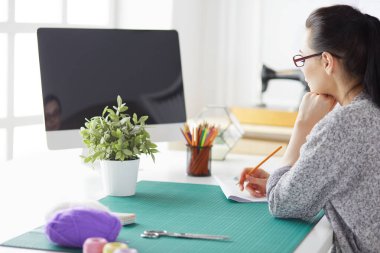 Güzel moda tasarımcısı stüdyoda duruyor.