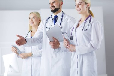 Meslektaşlarının önünde el sıkışan bir erkek doktor.