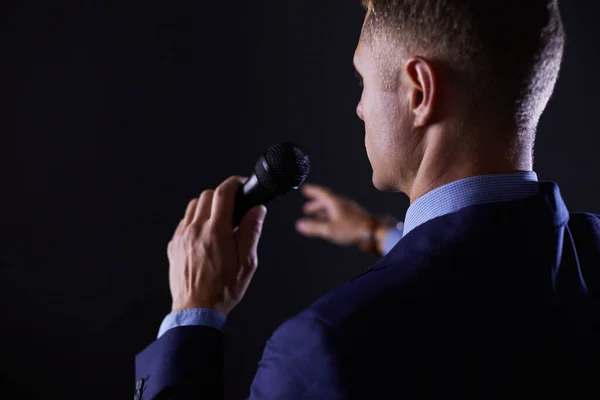 Porträt eines Geschäftsmannes, der mit einem Mikrofon steht und in die Zukunft blickt, spricht auf der Konferenz — Stockfoto