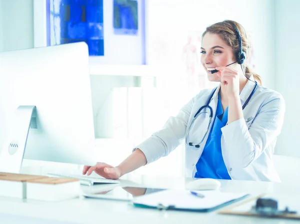 Mladý lékař doktor pracuje na recepci kliniky, je plánování schůzek a vyřizování telefonních hovorů — Stock fotografie