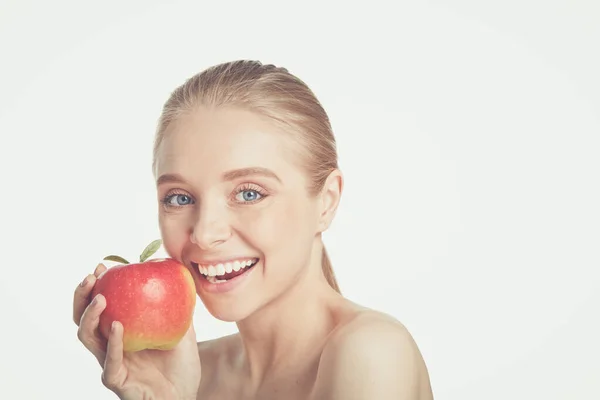 Retrato de feliz sonrisa joven hermosa mujer comiendo manzana roja, sobre fondo gris —  Fotos de Stock