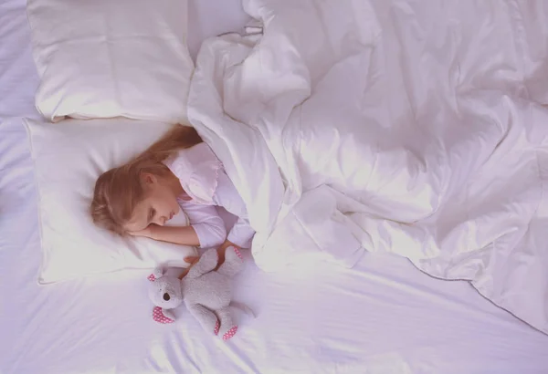 Niño niña duerme en la cama con un osito de peluche de juguete . —  Fotos de Stock