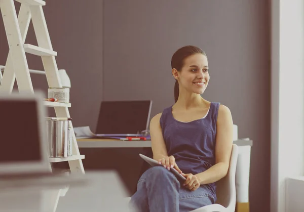 Giovane donna seduta alla scrivania con strumenti, piano e laptop. — Foto Stock