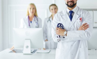Tıbbi grubun önünde genç bir erkek doktor.