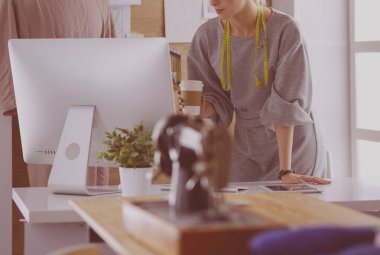 Moda tasarımcısı kadın dikiş makinesiyle dikiş dikiyor